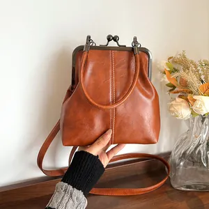 Vintage bruine lederen schelphandtas met kus-sluiting en verstelbare schouderriem