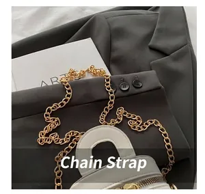 Detaillierte Ansicht des eleganten goldenen Kettenschultergurts einer weißen Beuteltasche