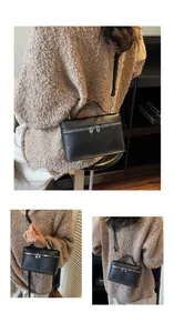 Detailansichten einer schwarzen Box-Tasche mit herzförmigen Reißverschlüssen an einem Modell.