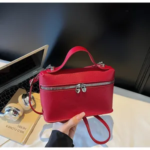 Rote minimalistische Handtasche mit herzförmigem Doppelreißverschluss im Detailbild.