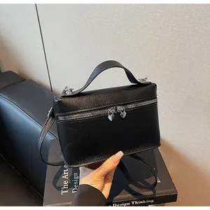 Nahaufnahme der schwarzen Handtasche aus geprägtem Leder mit Herz-Reißverschlüssen