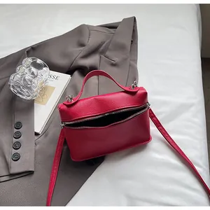 Detailansicht der roten Handtasche mit Litschi-Muster und silbernem Reißverschluss