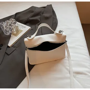 Detailansicht der weißen Handtasche aus Kieselleder mit offenem Reißverschluss und Innenfutter