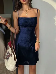 Dettaglio della trama di un elegante abito corto blu scuro con spalline in jacquard.