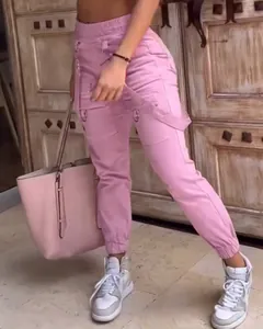 Close-up detail of stylish pink cargo pants featuring suspenders and functional pockets