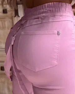 Close-up of pink casual pants featuring elastic waistband and decorative chain detail