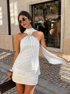 Stylish white polka dot halter top with gold buckle detail worn by a model