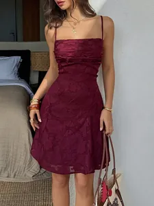 Dettaglio di un elegante abito corto bordeaux con spalline sottili e jacquard floreale