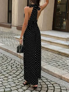 Back view of a chic black halter maxi dress with white polka dots and a large bow