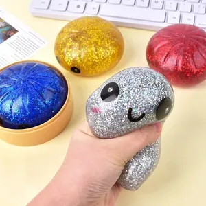 Close-up of a hand squeezing a silver glittery bun-shaped squishy toy