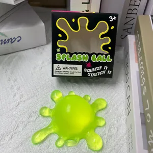 Detail eines lichtdurchlässigen grünen Stressballs in Virusform neben der Verpackung.