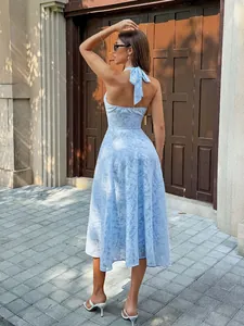 Back view of an elegant light blue halter dress featuring a delicate floral textured fabric