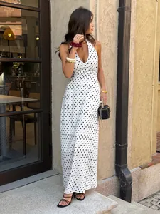 Elegant white halter neck maxi dress with black polka dots for summer fashion look