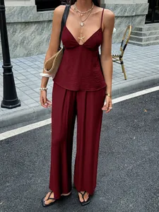 Ganzkörperansicht eines schicken burgunderroten Sets aus Camisole und weiten Hosen für den Sommer