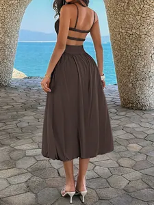 Rückansicht eines braunen rückenfreien Midikleids mit Riemchen für den Strandurlaub.