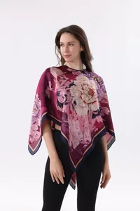 Vue détaillée d'un élégant poncho en soie à imprimé floral sur un mannequin en studio