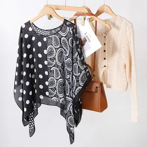 Détail d'un châle léger en soie imprimée avec motifs paisley et pois élégants
