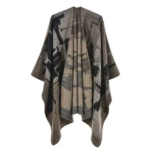 Dettaglio di uno scialle poncho in maglia stile etnico con motivi geometrici astratti.