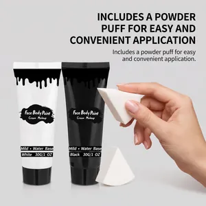 Primer plano de tubos de pintura facial y corporal blanco y negro con esponja de maquillaje