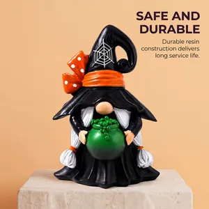 Detail of durable resin Halloween witch gnome figurine holding green cauldron