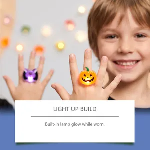 Nahaufnahme eines lächelnden Kindes mit einem leuchtenden Halloween-Kürbis-LED-Ring