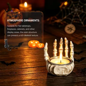 Close-up of resin skeleton hand candle holder with lit tealight for Halloween decor.