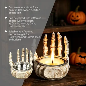 Macro detail of a Gothic skeleton hand candle holder with warm lit candle for Halloween