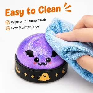 Detailansicht der Reinigung eines glitzernden Halloween-Squishy-Spielzeugs mit Tuch.