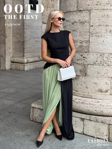 Élégante jupe longue tulipe plissée fendue vert et noir portée par un mannequin blond.