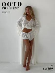 Elegant model wearing a semi-transparent white three-piece robe, top, and shorts set.