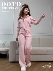 Macro view of the pink knitted two-piece set featuring double-zipper sweater and slim pants