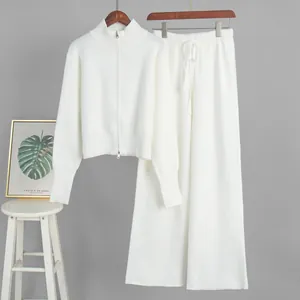 Elegant white knit two-piece set featuring two-way zip sweater and matching wide-leg pants.