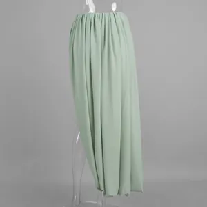 Détail du tissu plissé drapé et de la fente tulipe de la jupe longue vert sauge