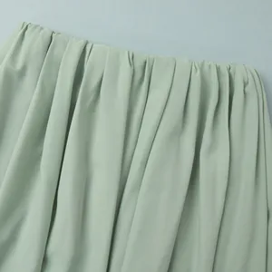 Détail d'une jupe plissée vert sauge montrant l'élastique et la texture drapée