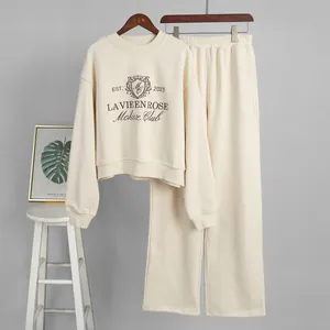 Detail of beige embroidered sweatshirt and wide-leg sweatpants two-piece set for women