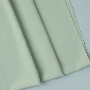 Détail de tissu plissé vert menthe montrant un drapé fluide et des coutures soignées