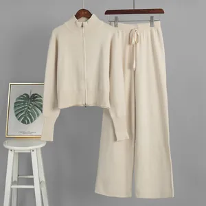 Elegant two-piece cream knit set featuring a double-zip sweater and wide-leg trousers.