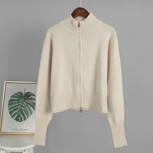 Close-up of cream knit cardigan with double-ended zipper and ribbed cuffs