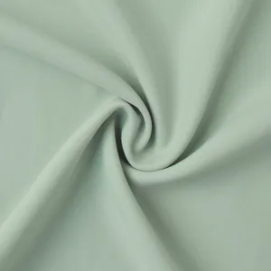 Détail macro du tissu vert clair doux avec un drapé très élégant pour jupe longue