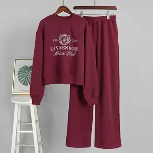 Close-up detail of the embroidered burgundy sweatshirt and matching lounge pants set