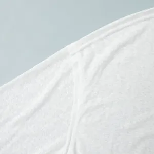 Close-up of semi-transparent white beachwear fabric showing detailed texture.