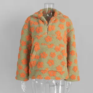 Detailed macro view of fuzzy fleece fabric with orange floral pattern on a warm hoodie