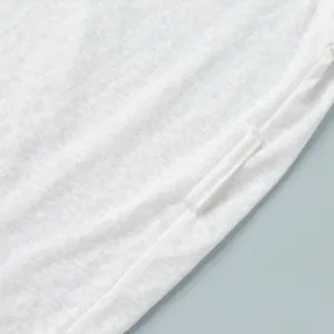Close-up detail of white semi-transparent fabric showing fine texture and seam