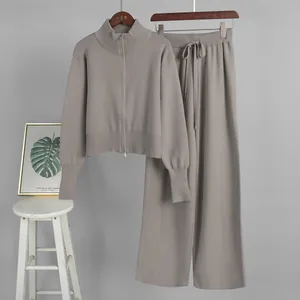 Detail of knitted two-piece set featuring double zipper top and wide-leg pants.