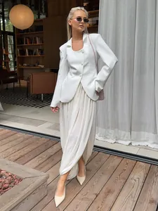 Jupe longue plissée tulipe blanche avec fente, portée par un mannequin sur terrasse