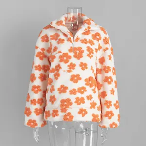 Macro view of white and orange floral fleece texture on a half-zip warm sweatshirt