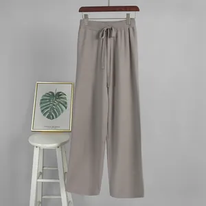 Full view of grey knitted wide-leg trousers with drawstring waist and rib texture.