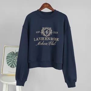 Close-up detail of navy blue sweatshirt featuring gold La Vie En Rose embroidery text