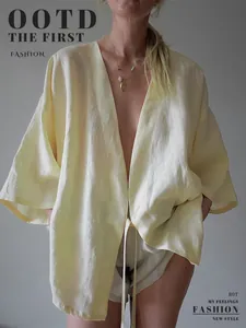 Loszittend lichtgeel kimono-shirt met V-hals en strikdetail aan de voorkant.