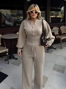 Vista de estilo de vida al aire libre de conjunto de punto beige con suéter y pantalón